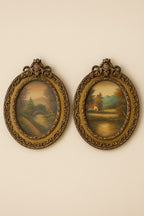 A pair of ornate oval frames with vintage landscape prints. Rich gilded detailing and classi...