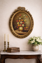 A lush bouquet in a gilded oval frame