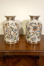 A matched pair of Chinese-floral ceramic vases covered in vibrant, multicolored vine and blossom ...