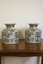 A matched pair of Chinese-floral ceramic vases covered in vibrant, multicolored vine and blossom ...