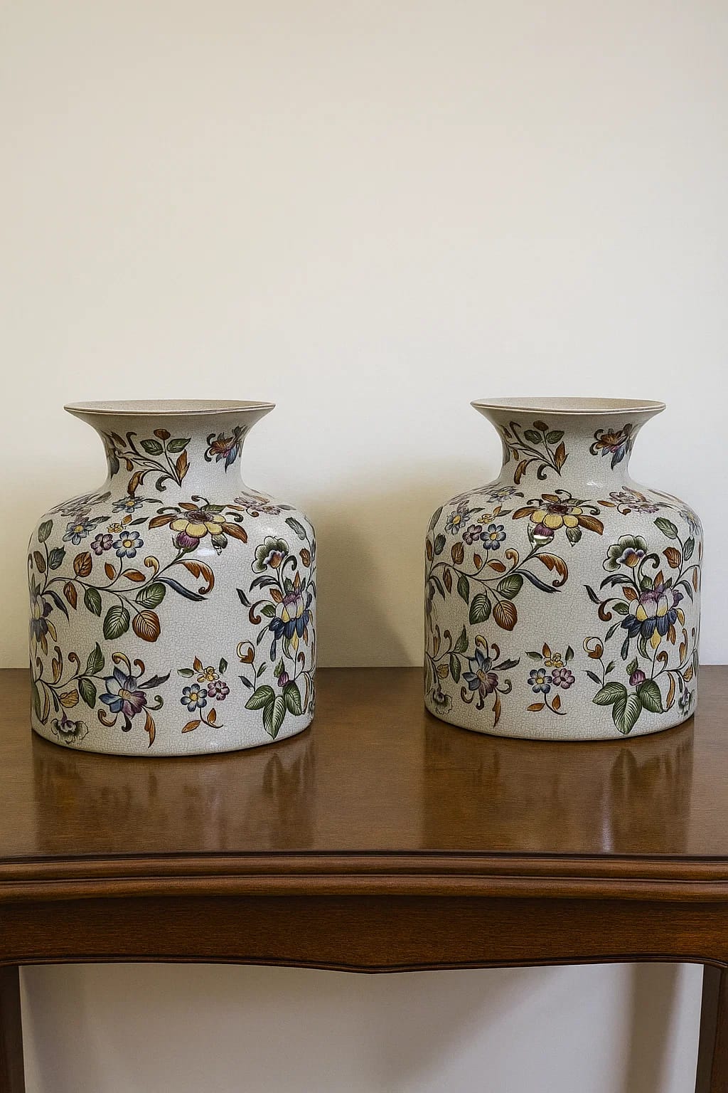 A matched pair of Chinese-floral ceramic vases covered in vibrant, multicolored vine and blossom ...