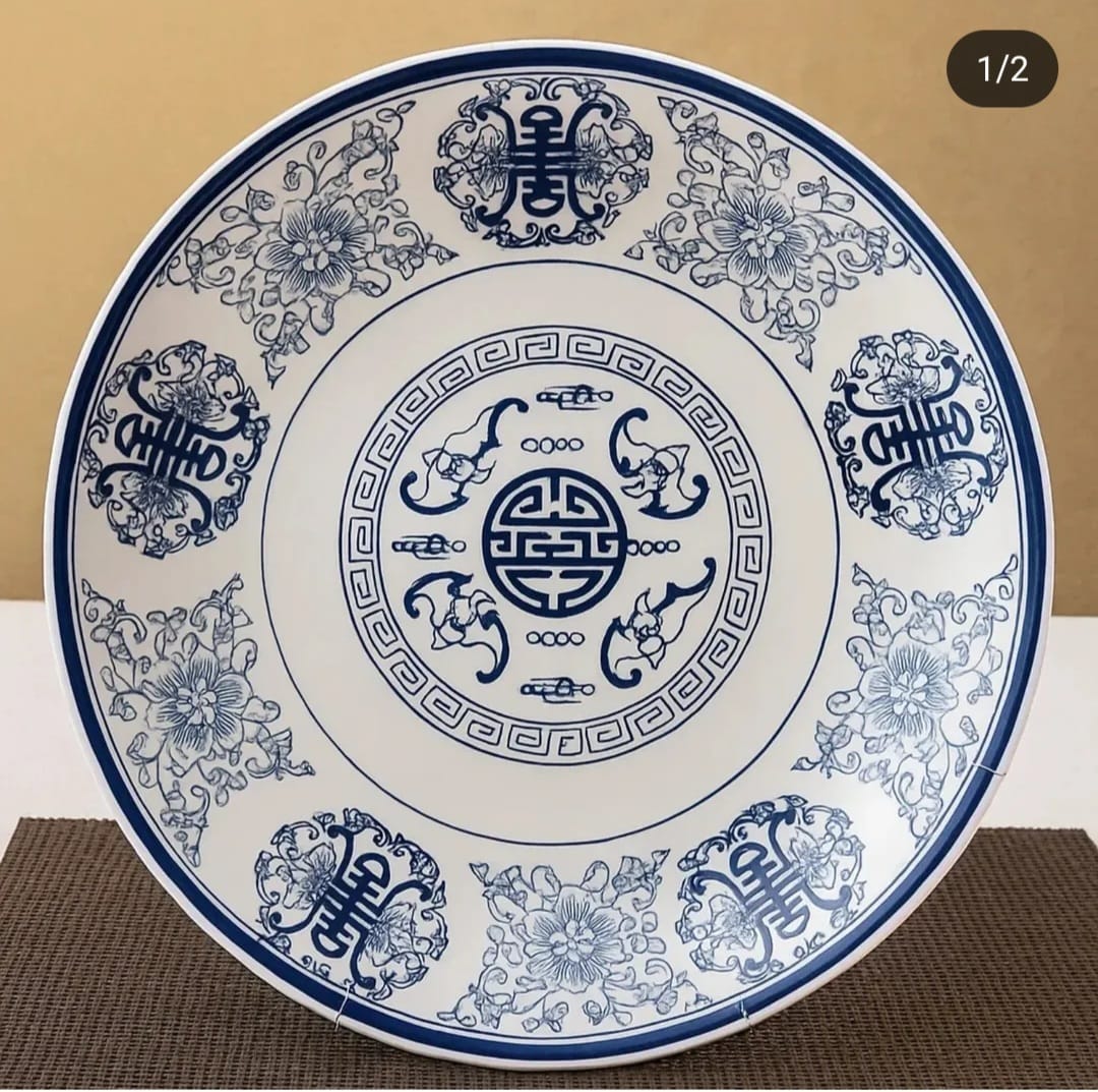 A striking 35 cm blue-and-white
ceramic plate featuring intricate
floral borders and a central med...